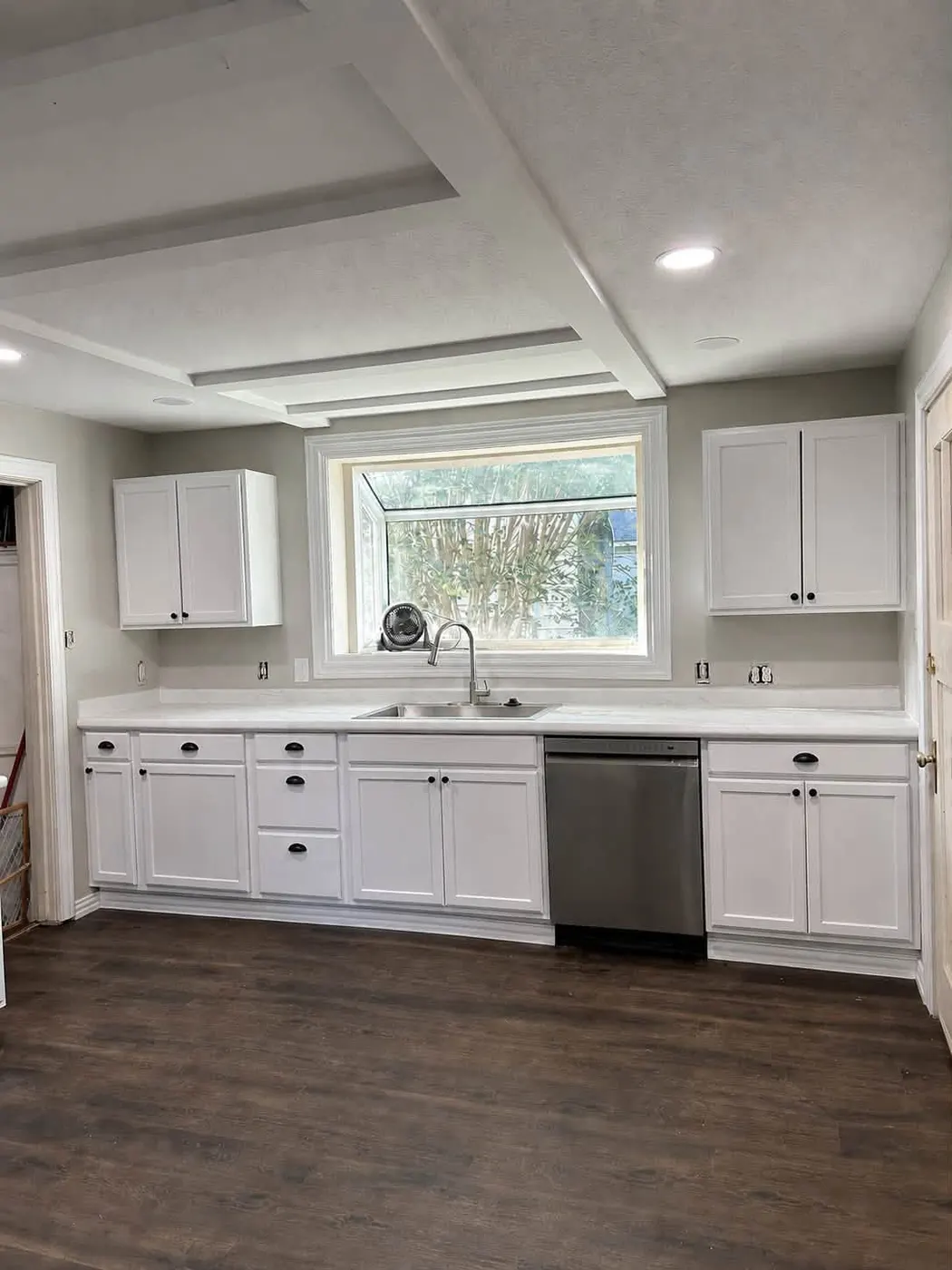 Kitchen remodel by TrueCraft with white cabinets and a garden window