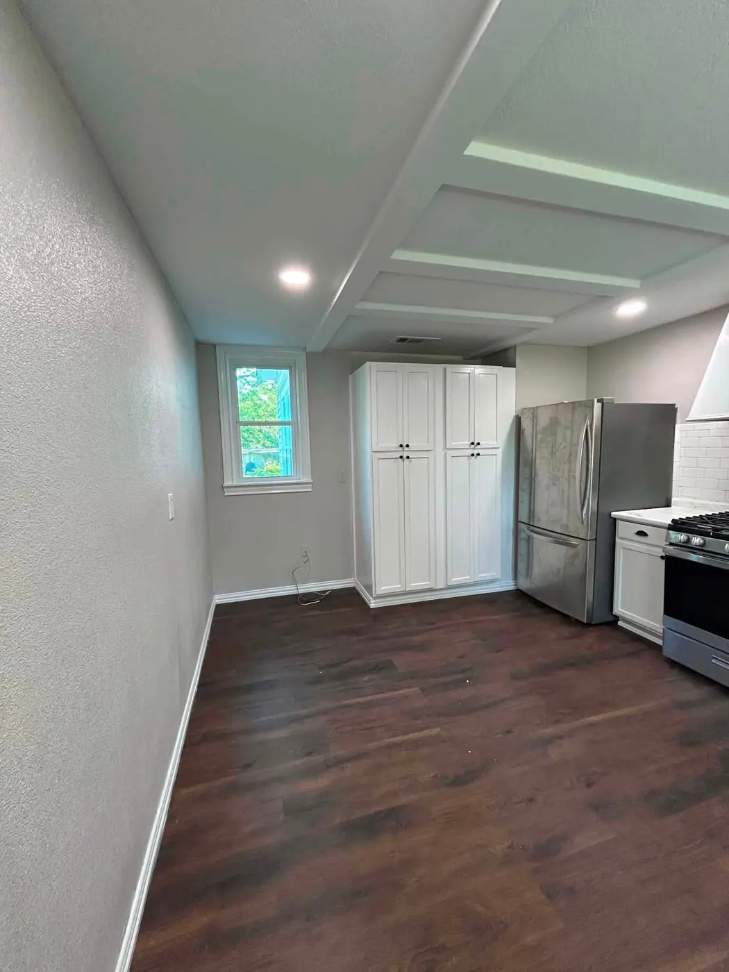 New dark vinyl plank floor installed over a repaired subfloor in a remodeled kitchen